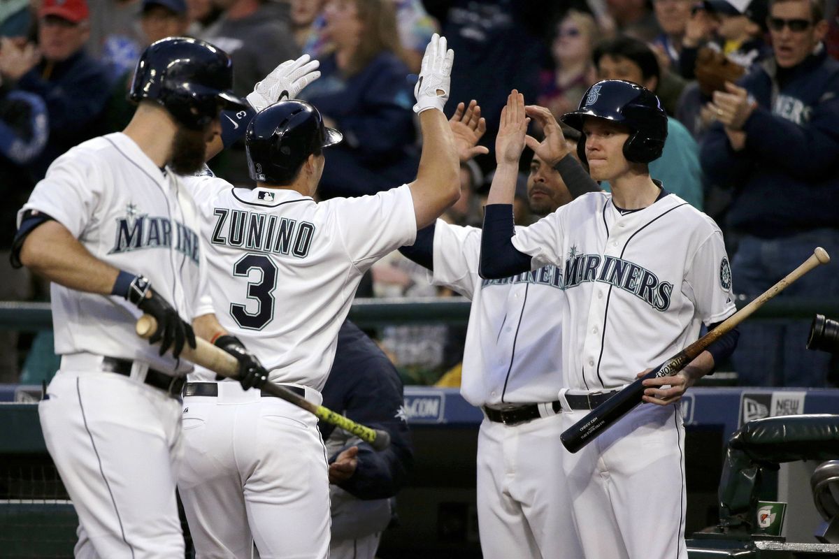 Mariners teammates greet Mike Zunino (3) after his solo homer in the fifth inning. (Associated Press)