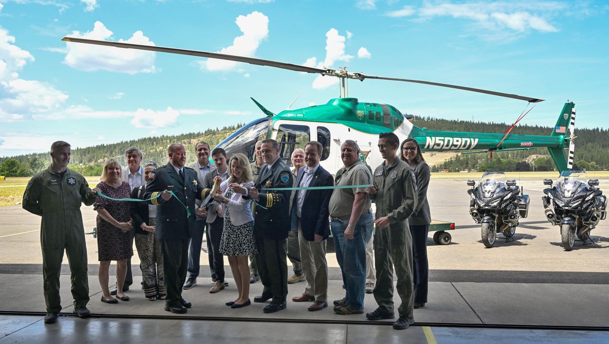 Representatives of Spokane County law enforcement and Spokane County government cut a ribbon on a new helicopter that was commissioned for service Wednesday, June 4, 2025, at Felts Field in Spokane, Washington.  (Jesse Tinsley/THE SPOKESMAN-REVIEW)
