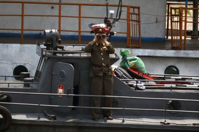 A North Korean soldier monitors a Chinese tour boat along the Yalu River, which divides China and North Korea. The latest nuclear test has strained the two countries’ previously friendly relations.  (Associated Press / The Spokesman-Review)