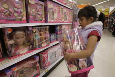 
Six-year-old Yvette Ibarra holds a Dancing Princess Barbie doll while shopping at a Toys 