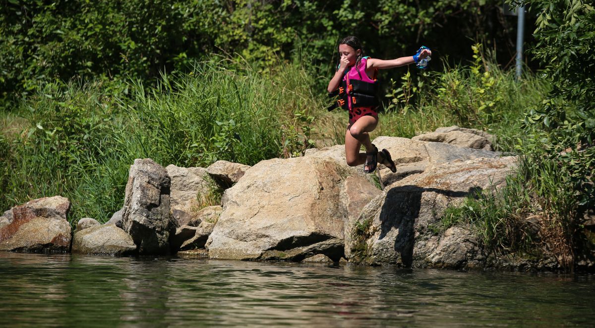 Adelynn Kennedy, 8, jumps off of a rock into the Little Spokane River on Sunday at Pine River Park in north Spokane. Another heat wave bringing near-triple-digit temperatures is expected to last until Thursday.  (Libby Kamrowski/ THE SPOKESMAN-REVIEW)