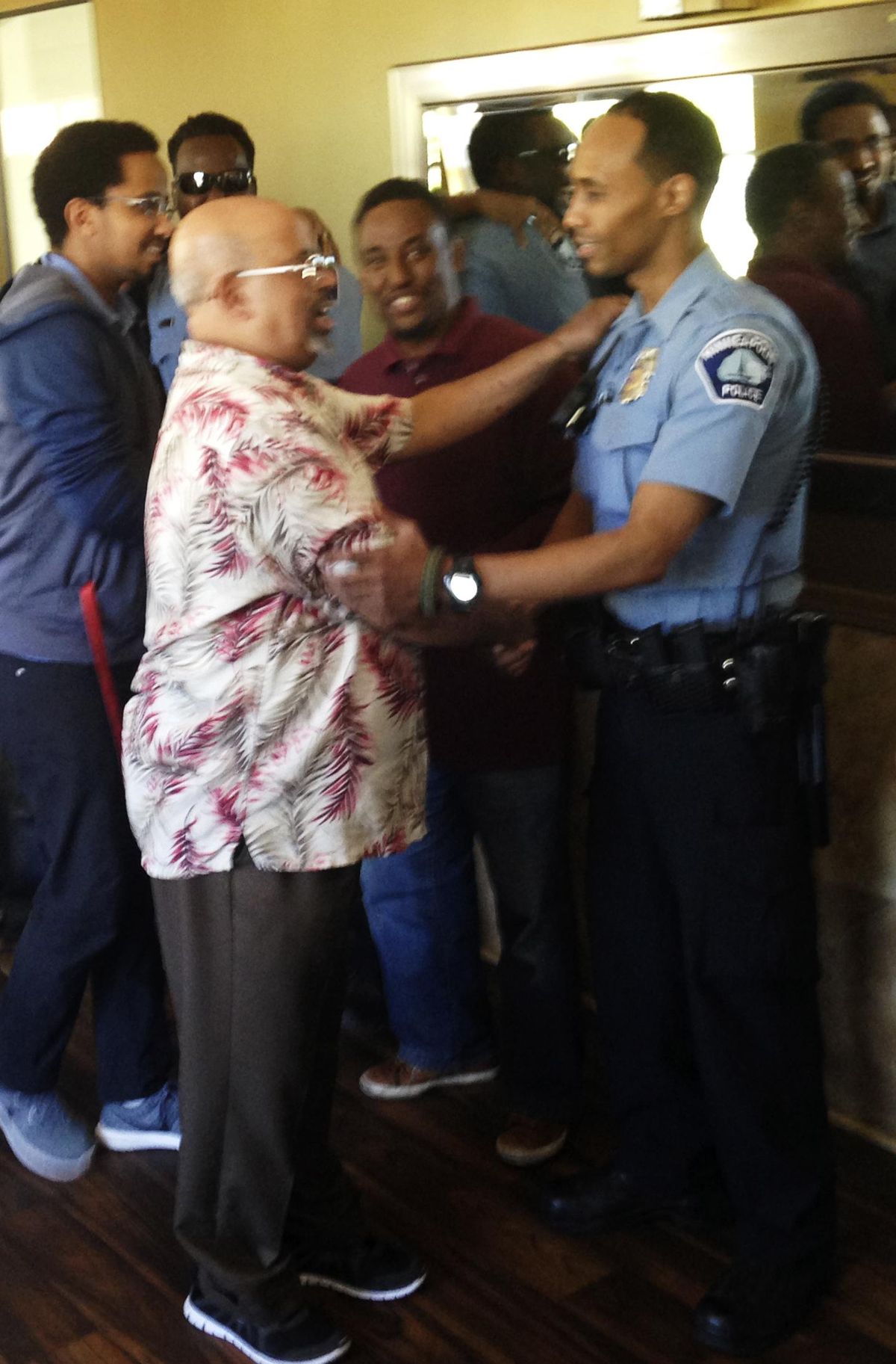 In this May 2016 photo provided by the City of Minneapolis, police Officer Mohamed Noor, right, is greeted by a well-wisher at a community event welcoming him to the Minneapolis police force. (AP)