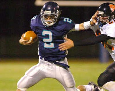 
Lake City quarterback Zach Clanton stiff-arms a Post Falls defender Friday. 
 (Jesse Tinsley / The Spokesman-Review)