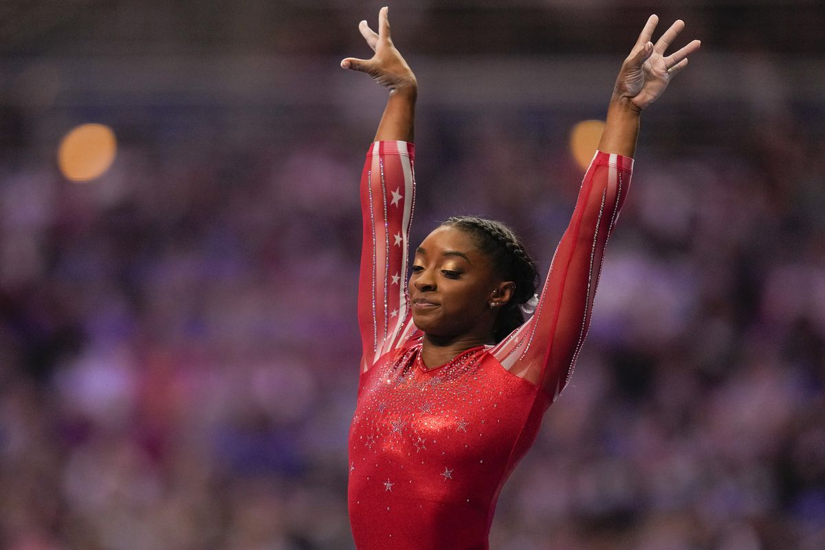 Simone Biles lands after competing on the vault during the women