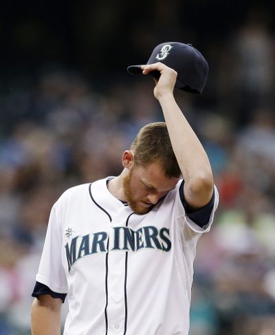 M’s reliever Charlie Furbush wipes his face after giving up a home run. (Associated Press)