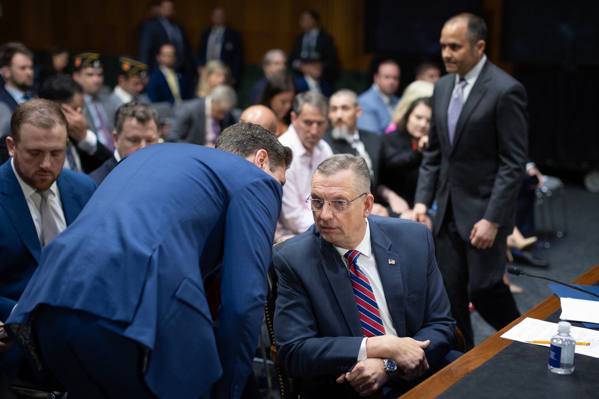 Secretary of Veterans Affairs Douglas A. Collins speaks to a staff member before testifying before a Senate Committee on Veterans’ Affairs hearing on May 6 at the U.S. Capitol in Washington.  (Tom Brenner/For the Washington Post)