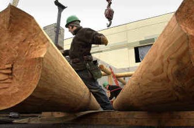 
Delmar Romero, left, and Jasper Naumann of Nature's Touch construct what will be a log cabin entrance to the huge Buck Knives' plant in Post Falls.
 (Brian Plonka / The Spokesman-Review)