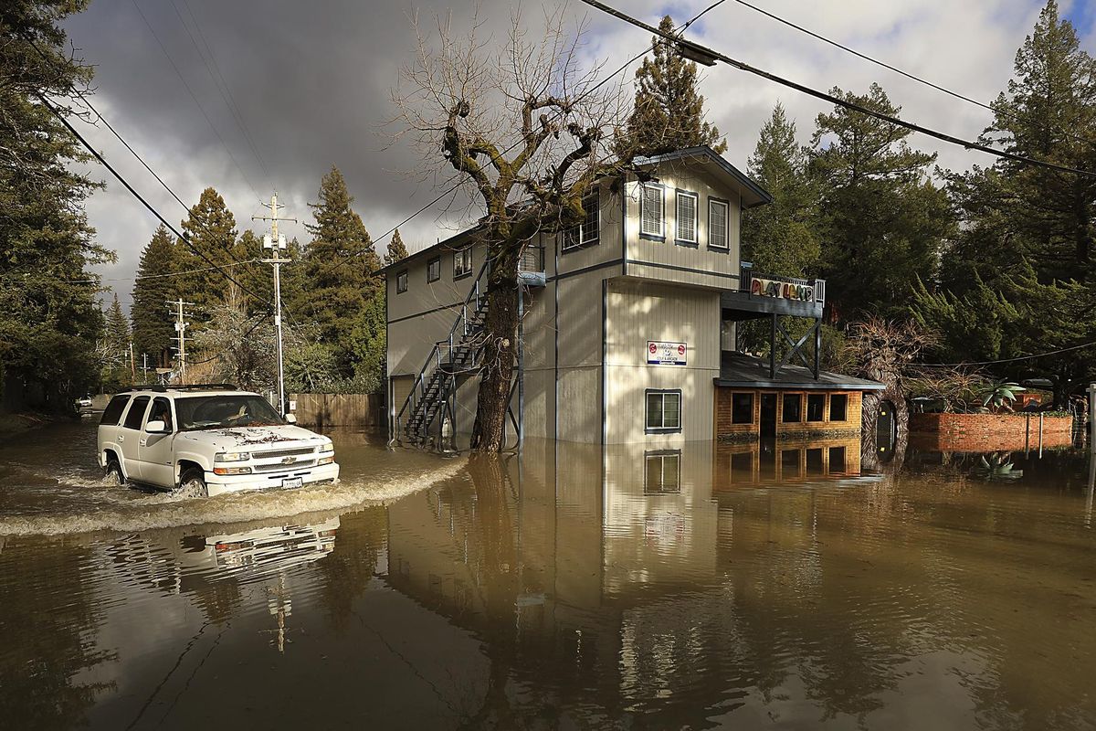 Drake Road is flooded by the Russian River at the Pee Wee Golf and Arcade of Guerneville, Calif., Thursday, Feb. 14, 2019. Waves of heavy rain pounded California on Thursday, trapping people in floodwaters, washing away a mountain highway, triggering a mudslide that destroyed homes and forcing residents to flee communities scorched by wildfires last year. (Kent Porter / AP)