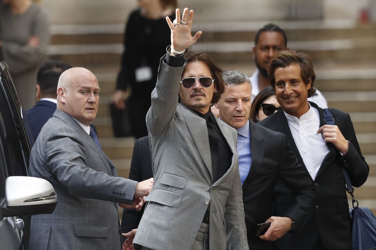 American actor Johnny Depp, waves Tuesday, July 28, 2020, as he leaves after the end of the trial at the High Court in London. The UK High Court has ruled against Johnny Depp in his libel suit against the owner of the Sun newpaper over wife-beating allegation, it was reported on Monday, Nov. 2, 2020.   (Associated Press)
