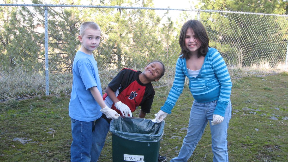 Students at Liberty Park Child Development Center in Spokane sometimes are invited to go outdoors and clean up the property, a task that helps take pride in their neighborhood and also learn eco-healthy principles. From left, Charlie Golding, Shug Burden and Cierra Morris. 
  (Sandra Hosking  / Down to Earth NW)
