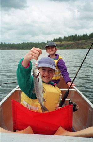 Emma Scherer of Spokane  holds a trout she landed while fishing out of a canoe on Badger Lake with her friend, Hillary Landers, in this 1998 photo. (Rich Landers)