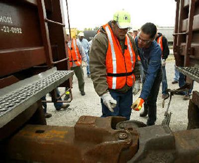 
New Union Pacific Railroad employee Cody Krause, left, and peer instructor Pat McGovern go over how to joinboxcars together during a training session at the Union Pacific rail yard in Boone, Iowa. 
 (Associated Press / The Spokesman-Review)