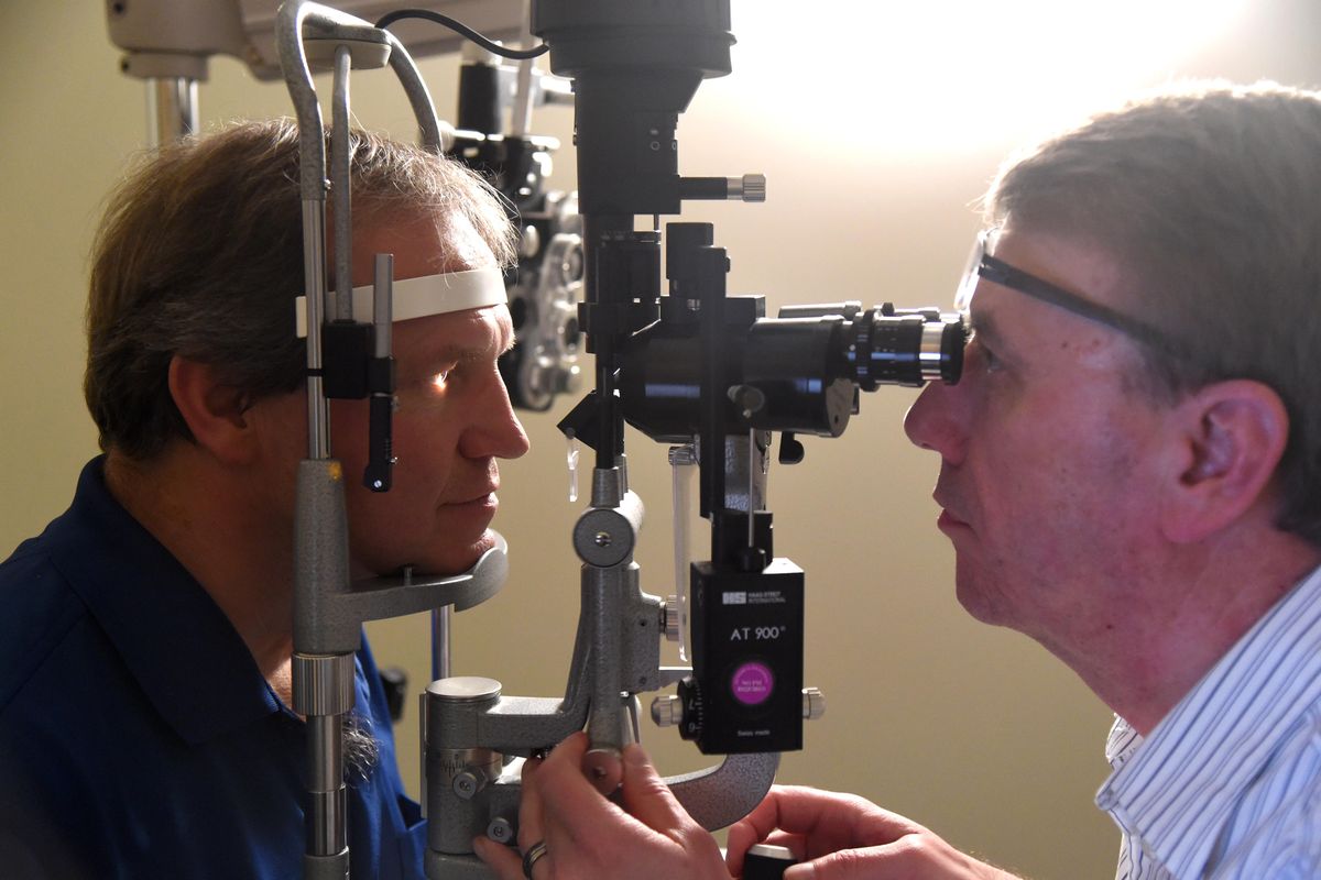 Les Hannemann, left, of Davenport,  gets an eye examination from Dr. Don Petersen,  an optometrist at the Riverfront Medical Center, Friday in downtown Spokane. Group Health announced that health care giant Kaiser Permanente will take over the HMO, giving the larger health care organization a foothold in the Northwest. (Jesse Tinsley / The Spokesman-Review)