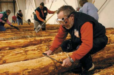 
John Markham of Arch Cape, Ore., uses a draw-knife to strip bark off a log Dec. 10 as he and more than 100 volunteers, many from out of state, came to the Clatsop County Fairgrounds in Oregon to help with the new Fort Clatsop replica. 
 (Associated Press / The Spokesman-Review)