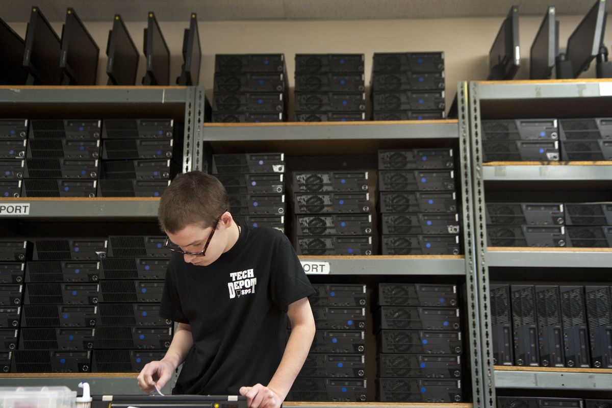 Josiah McCall cleans a laptop at Instructional Tech Support in Spokane Valley on Friday, Dec. 7, 2018. (Kathy Plonka / The Spokesman-Review)