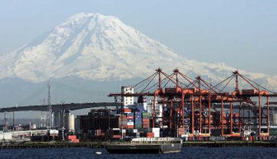 
Mount Rainier looms behind cranes and stacked cargo containers at the Port of Seattle last month as viewed from a Washington State ferry boat near Seattle. 
 (Associated Press / The Spokesman-Review)