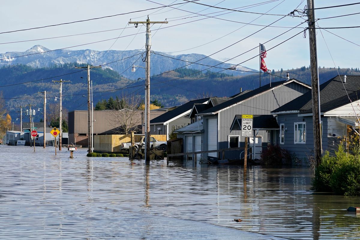 Floodwater inundates homes along a road Wednesday, Nov. 17, 2021, in Sumas, Wash. An atmospheric river—a huge plume of moisture extending over the Pacific and into Washington and Oregon—caused heavy rainfall in recent days, bringing major flooding in the area.  (Elaine Thompson)
