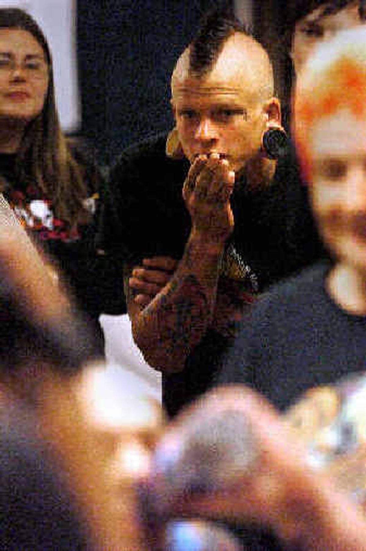 
Mike Wells, 19, of Idaho Falls, watches with apprehension as piercers Fay Hammond and Colleen Weenis apply a "crown of thorns," a piercing consisting of a ring of interlaced needles poked through the scalp of apprentice tattoo artist Jon Slichter, at the Ink Travelers tattoo and body piercing convention Saturday. 
 (Jesse Tinsley / The Spokesman-Review)