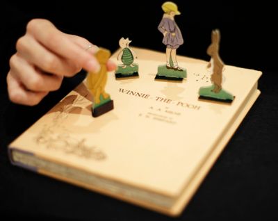 A first U.S. edition of Winnie the Pooh signed by the author A.A. Milne and illustrator E.H. Shepard is displayed with cut-outs representing characters from the book at offices of the Sotheby’s auction house in London, Monday, Dec. 15, 2008. “Winnie the Pooh” and “The Sun Also Rises” are going public. A.A. Milne’s children’s book and Ernest Hemingway’s novel are among the works from 1926 whose copyrights will expire Saturday, Jan. 1, 2022, putting them in the public domain in 2022.  (Matt Dunham)