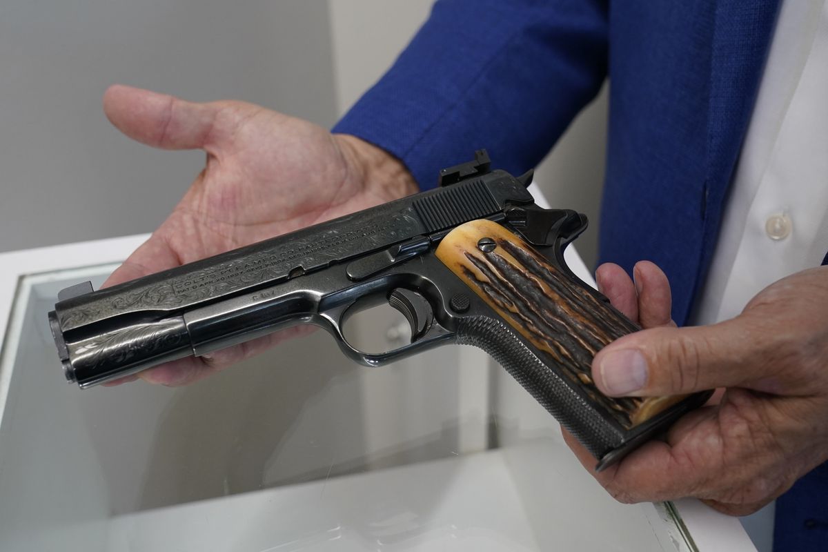 Brian Witherell displays a Colt .45-caliber pistol that belonged to mob boss Al Capone, at Witherell’s Auction House in Sacramento, Calif., on Aug. 25.  (Rich Pedroncelli)