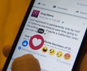 Julie Zhuo, product design director at Facebook, demonstrates the new emoji-like stickers customers will be able to press in addition to the like button. Facebook's Like button is getting some company, as the company rolls out alternatives worldwide after testing in a few countries. (AP Photo/Mary Altaffer)