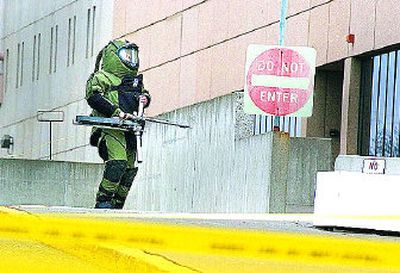 
A member of the police and sheriff's  bomb disposal unit enters the breezeway between the Spokane County Courthouse and Public Safety Building Tuesday. 
 (Christopher Anderson / The Spokesman-Review)