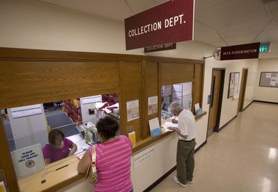 People visit windows at the collection department at the Yakima County Courthouse in Yakima on June 12. (Associated Press / The Spokesman-Review)
