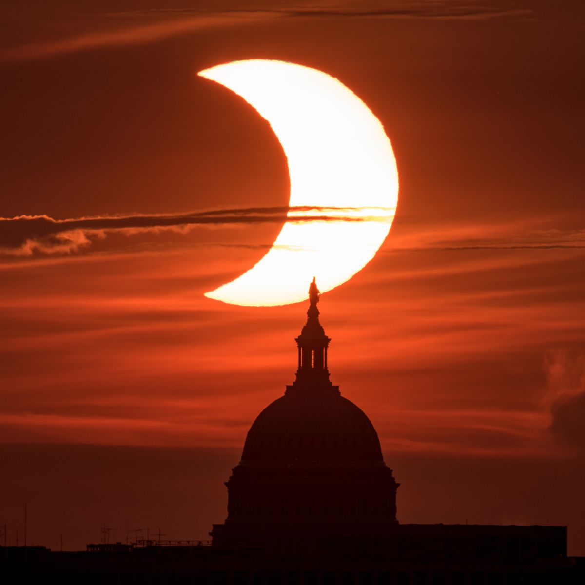 A partial solar eclipse is seen from Arlington, Virginia, as the sun rises behind the Capitol on June 10. The annular or “ring of fire” solar eclipse was only visible to some people in Greenland, Northern Russia and Canada.  (Bill Ingalls/NASA)