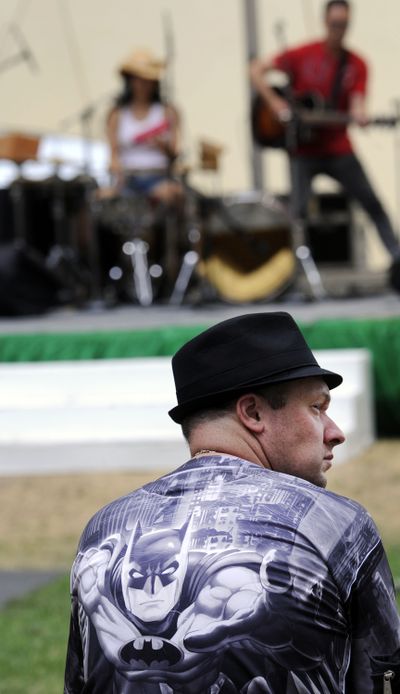 Music in the air: Scott Spence listens to the band at Q’emiln Park as the Post Falls Festival begins on Friday. The three-day event includes bands, food and craft booths. (Kathy Plonka)