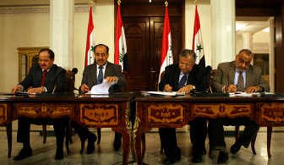 
Iraqi Prime Minister Nouri al-Maliki, second from left, and President Jalal Talabani, second from right, are flanked by Massoud Barzani, left, the leader of the Kurdish region,  and Iraqi Vice President  Adel Abdul Mahdi as they sign an  agreement on a new alliance Thursday.Associated Press
 (Associated Press / The Spokesman-Review)