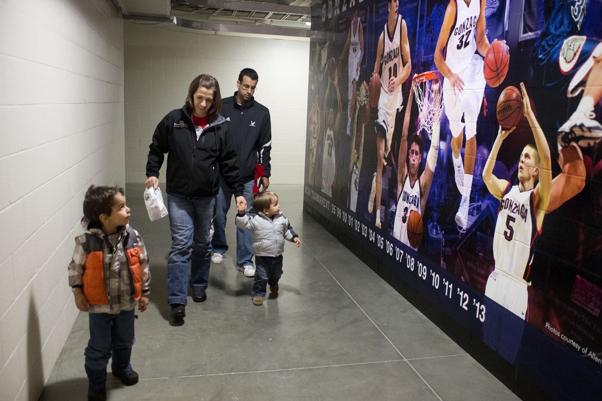 Craig Fortier, Lisa Mispley Fortier, and sons Marcus, left, and Calvin, right, walk through a hallway at McCarthey Athletic Center. (Jesse Tinsley)