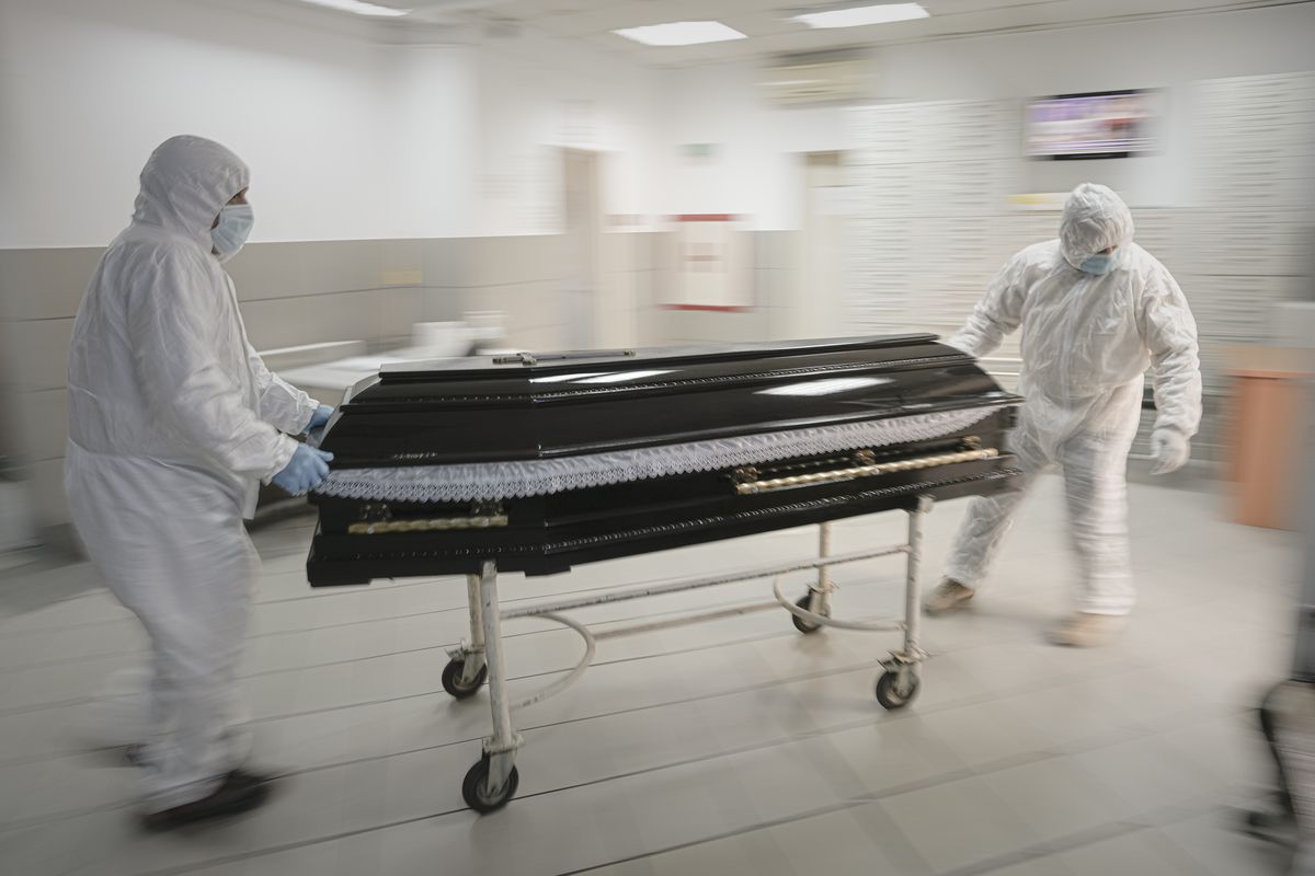 Funeral house employees drag a coffin on a trolley as they arrive at the University Emergency Hospital morgue to take a COVID-19 victim for burial, in Bucharest, Romania, Monday, Nov. 8, 2021. This was supposed to be the Christmas in Europe where family and friends could once again embrace holiday festivities and one another. Instead, the continent is the global epicenter of the COVID-19 pandemic as cases soar to record levels in many countries. With infections spiking again despite nearly two years of restrictions, the health crisis increasingly is pitting citizen against citizen — the vaccinated against the unvaccinated.  (Vadim Ghirda)
