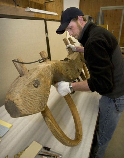 
Temporary Capitol Curator Jason Gray works at cataloging a 19th century oxen yoke that was donated last year at the Idaho State Historical Museum's warehouse in Boise. 
 (Associated Press / The Spokesman-Review)