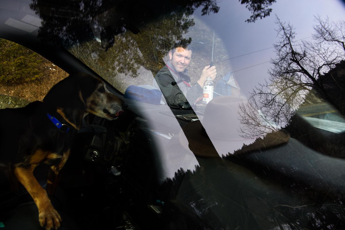 Bart George, a biologist with the Kalispel Tribe smiles at his hound Whisper as she watches him from the cab of his truck while researching mountain lions on Tuesday, Feb. 25, 2020, near Colville, Wash. George uses GPS collars to track mountain lions and see how they respond to pressure from humans and dogs. (Tyler Tjomsland / The Spokesman-Review)