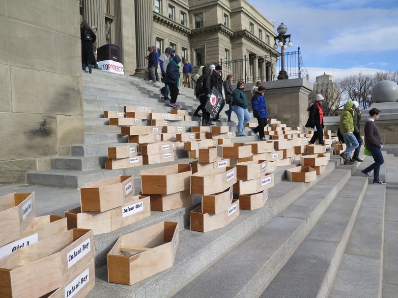 Protesters stacked 183 symbolic child-sized coffins on the Idaho Capitol steps on Monday, Feb. 19, 2018, calling for Idaho to repeal its faith-healing exemption, which allows parents to deny their children medical care without civil or criminal liability, even if the children die. (Betsy Z. Russell)