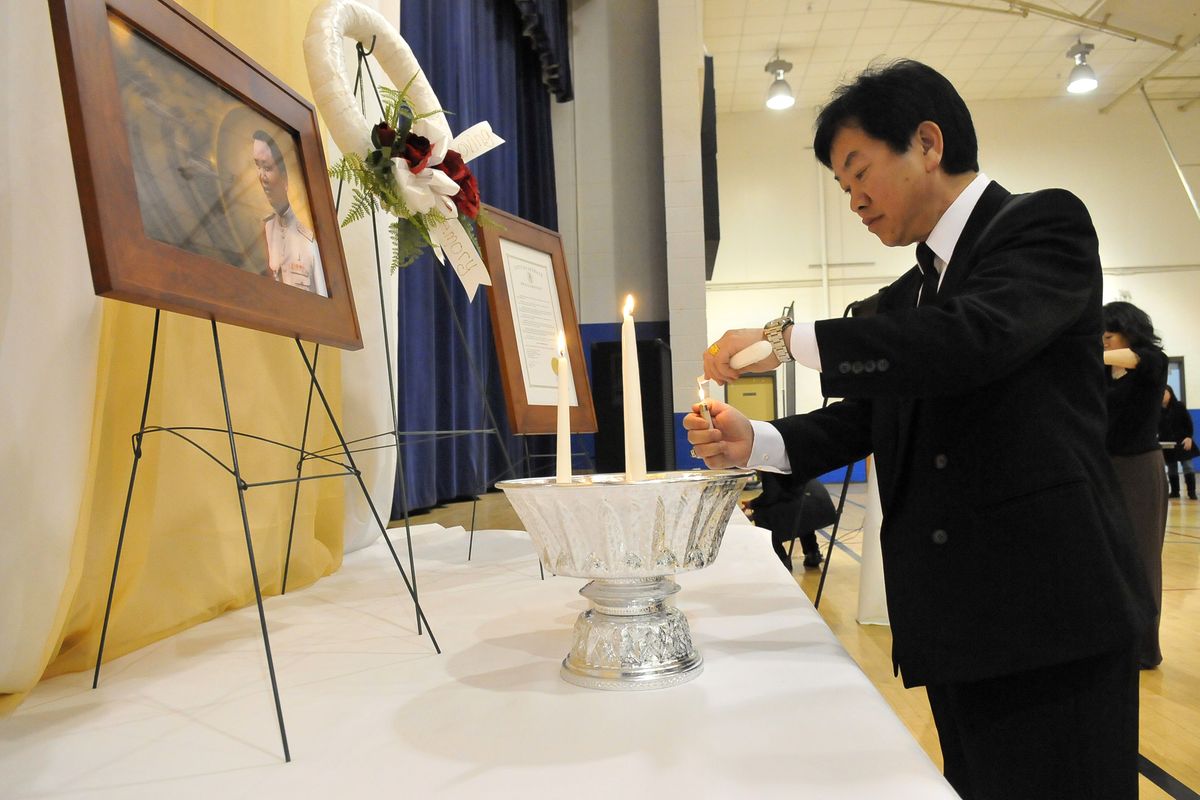 Vang Xiong lights candles before a portrait of Gen. Vang Pao at the East Central Community Center in Spokane on Saturday during a memorial service for Pao, who died Jan. 6 in California. He was revered as a leader of the Hmong community in the United States.  (PHOTOS BY JESSE TINSLEY)
