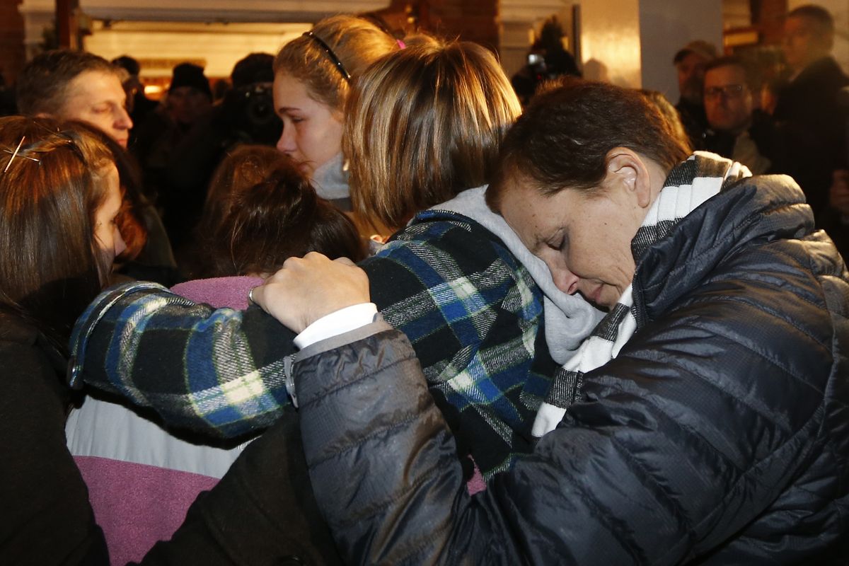 Girls embraces outside St. Rose of Lima Roman Catholic Church, which was filled to capacity, during a healing service held in for victims of an elementary school shooting in Newtown, Conn., Friday, Dec. 14, 2012. A gunman opened fire at Sandy Hook Elementary School in Newtown, killing 26 people, including 20 children. (Charles Krupa / Associated Press)