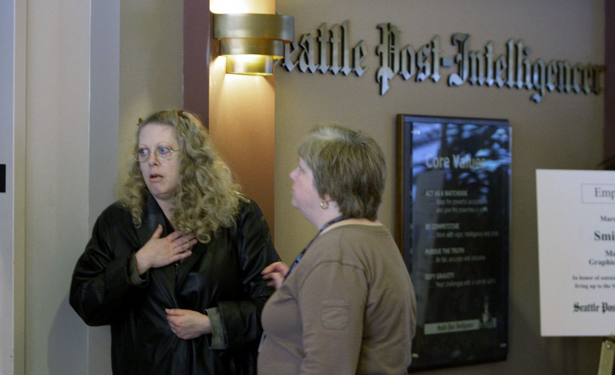Seattle Post-Intelligencer news researcher Marsha Milroy, left, gets word of the newspaper closing from Cecelia Goodnow outside the newsroom Monday in Seattle. Hearst Corp., which owns the 146-year-old P-I, said it will print its final edition today.Associated Press photos (Associated Press photos / The Spokesman-Review)