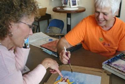 
Gallery West co-owner Dian Zahner, right, and Christ Kitchen director Jan Martinez discuss the cutting-edge watercolor rendition of the Christmas story Zahner donated to last year's art auction and luncheon. 
 (The Spokesman-Review)