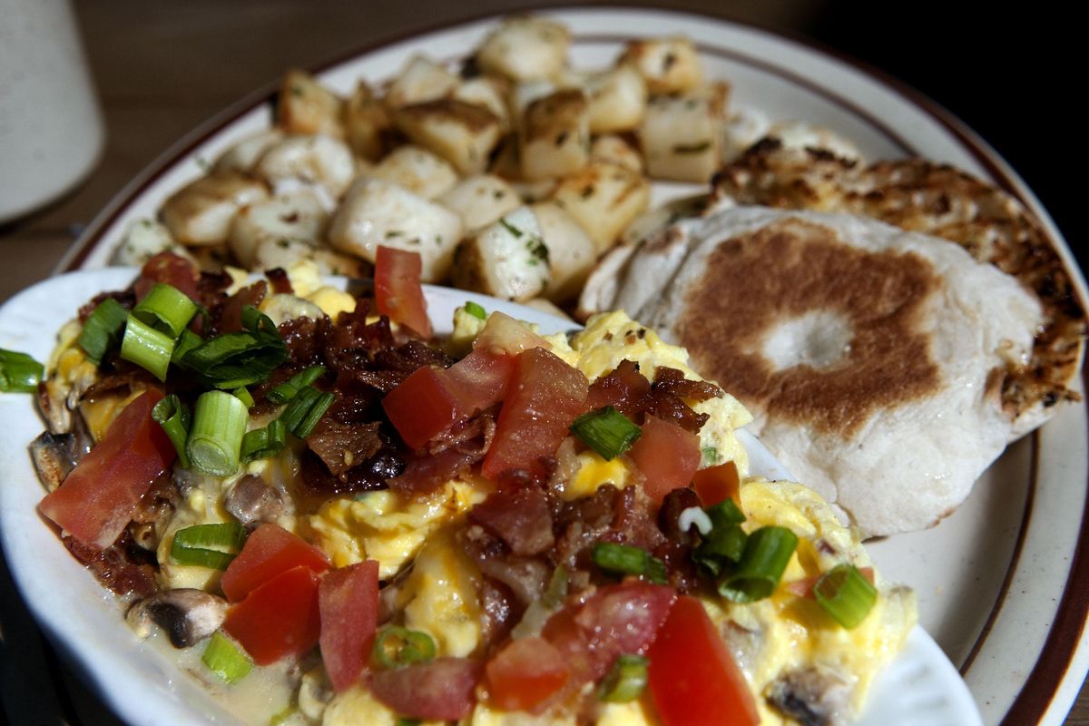 The Dawn Breaker at LePeep restaurant in Coeur d’Alene consists of eggs scrambled together with mushrooms and crisp bacon, topped with melted jack and cheddar cheese, tomatoes, bacon and green onions. Served with peasant potatoes and a choice of English muffin. (Kathy Plonka / The Spokesman-Review)