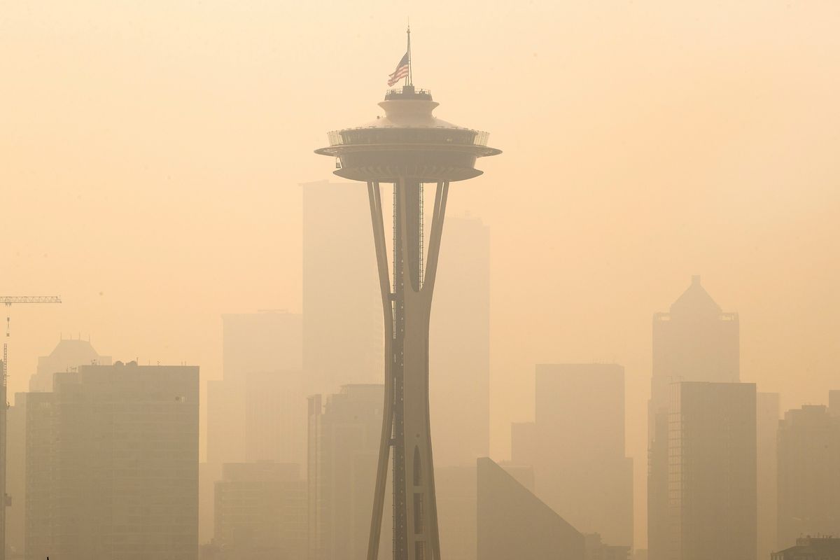 FILE - In this Sept. 11, 2020, file photo, an American flag on top the Space Needle was lowered to half-staff today by the Seattle Fire Department to remember those who lost their lives on 9/11, Friday, Sept. 11, 2020. Thick smoke from wildfires burning across Washington, Oregon and California makes seeing the Space Needle and downtown Seattle nearly impossible in this view from Queen Anne Hill.  (Mike Siegel)