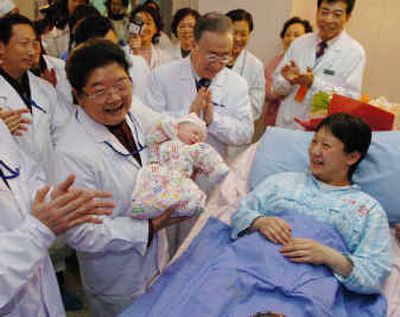 Holding the newborn baby, Gu Xiulian, , chairwoman of the All-China Women's Federation congratulates the mother at Beijing Maternity Hospital in Beijing early Thursday.
(Associated Press / The Spokesman-Review)