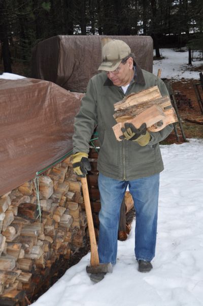 Pat Munts’ husband Steve collects an armload of locust firewood. Locust is the best firewood in this area because it generates a lot of heat, but it needs to be split with a log splitter because of its twisted grain. (Pat Munts/For The Spokesman-Review)