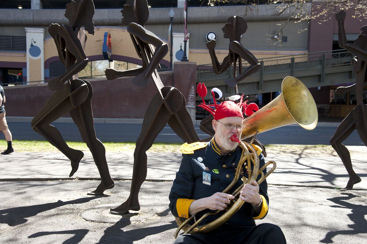 Leonard Byrne, of the P-Jammers and wearing a crab hat, warms up on his helicon, a brass musical instrument in the tuba family, before leading and participating in the Earth Day Procession of the Species parade on Saturday in Riverfront Park. (Dan Pelle)