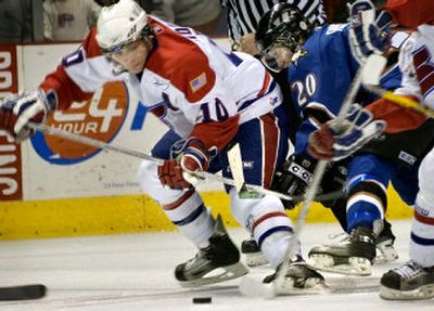 
Adam Hobson of Spokane, left, and Ryan Russell of Kootenay joust for a loose puck Friday night in the Arena. Hobson had two goals, but the Chiefs lost 5-4 in overtime. 
 (Holly Pickett / The Spokesman-Review)