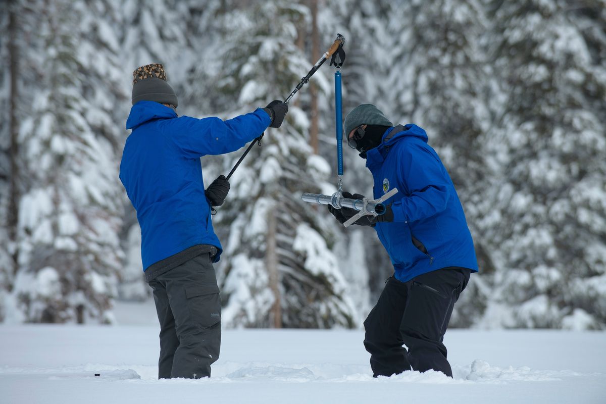 FILE — Anthony Burdock, left, and Sean de Guzman, chief of snow surveys for the California Department of Water Resources, check the depth of the snow pack during the first snow survey of the season at Phillips Station near Echo Summit, Calif., Thursday, Dec. 30, 2021. Southern California