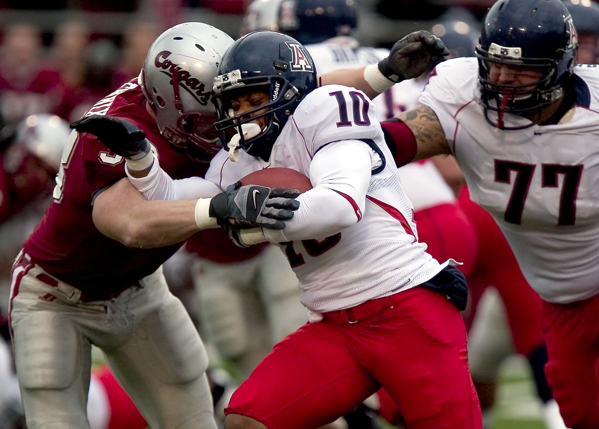 WSU defensive end Matt Mullennix tackles Arizona receiver Mike Thomas.  (Associated Press / The Spokesman-Review)