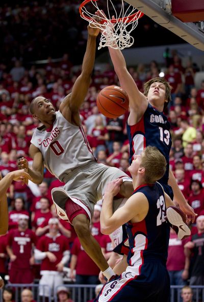 WSU’s Marcus Capers, left, dunks over Gonzaga defenders Kelly Olynyk (13) and Mathis Monninghoff In the first half. (Colin Mulvany / The Spokesman-Review)