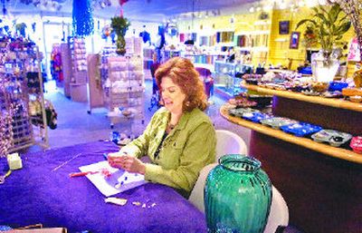 Tracy Mielke  has filled her shop Bead Addicts Attic on West Garland Avenue with a wide variety of beads and specialty items. During a lull between customers she works on one of her own creations. 
 (CHRISTOPHER ANDERSON / The Spokesman-Review)