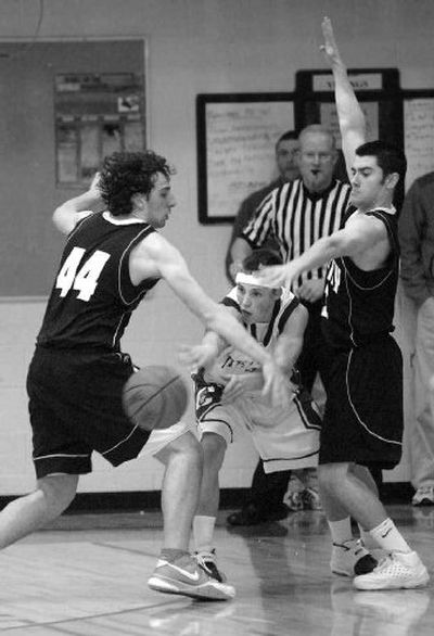 
CdA's Nate Clinton slips a pass between Lake City's Nick Fromm, left, and Tyler Stoddard. 
 (Jesse Tinsley / The Spokesman-Review)